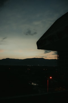 A dark, cinematic storyboard frame showing a futuristic cityscape at dusk.