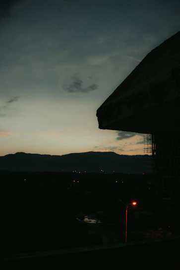 A moody, cinematic shot of Karachi’s cityscape at dusk with subtle film grain overlay.