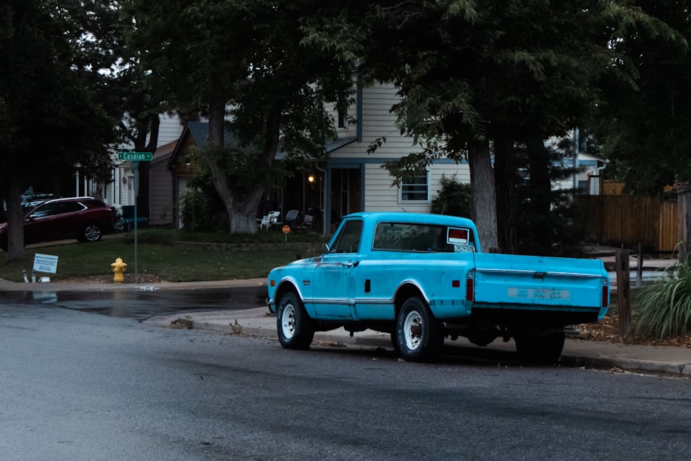 a blue truck parked on the side of the road