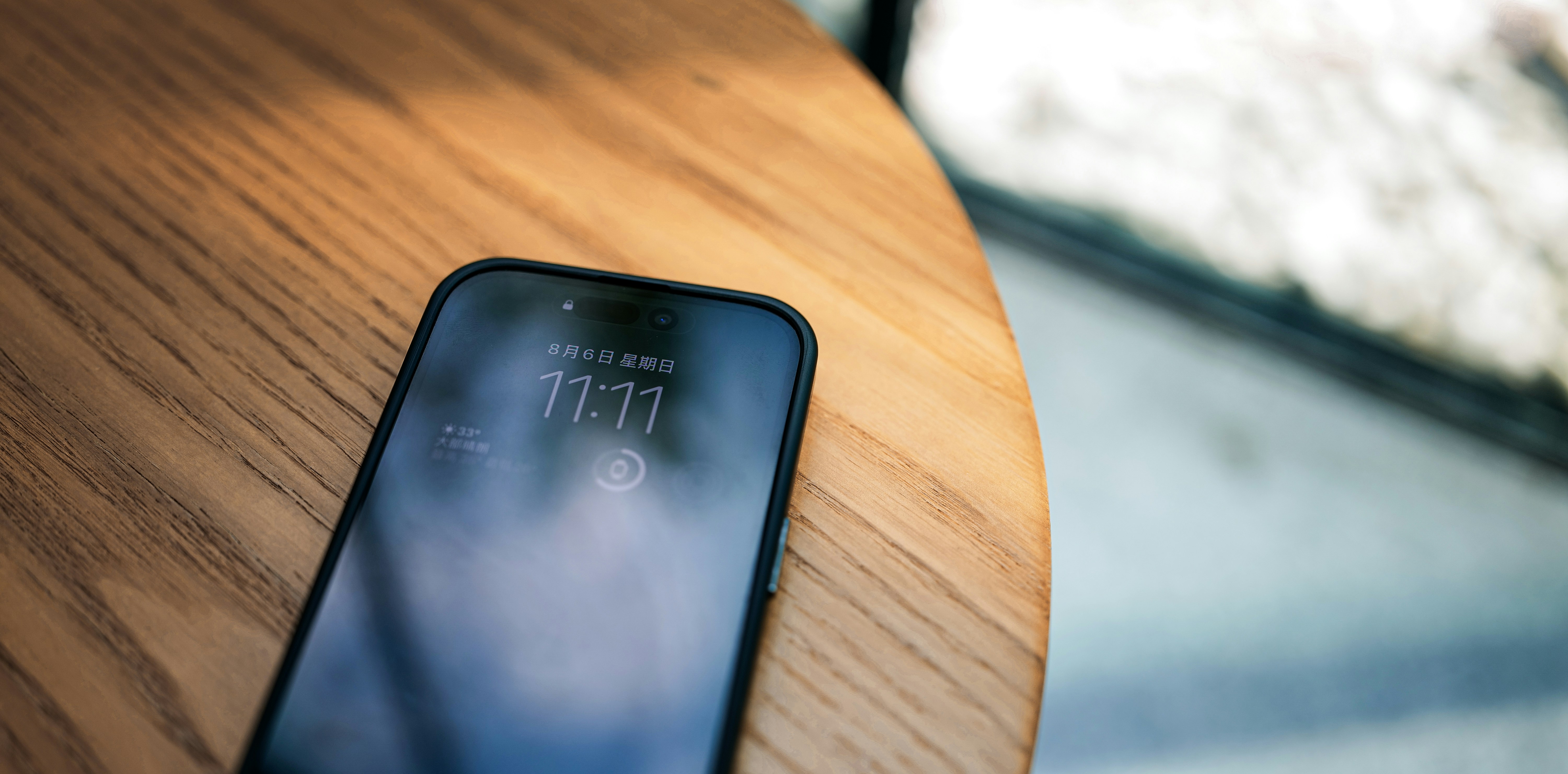 close up shot of an iPhone screen displaying iOS settings icon on a wooden table