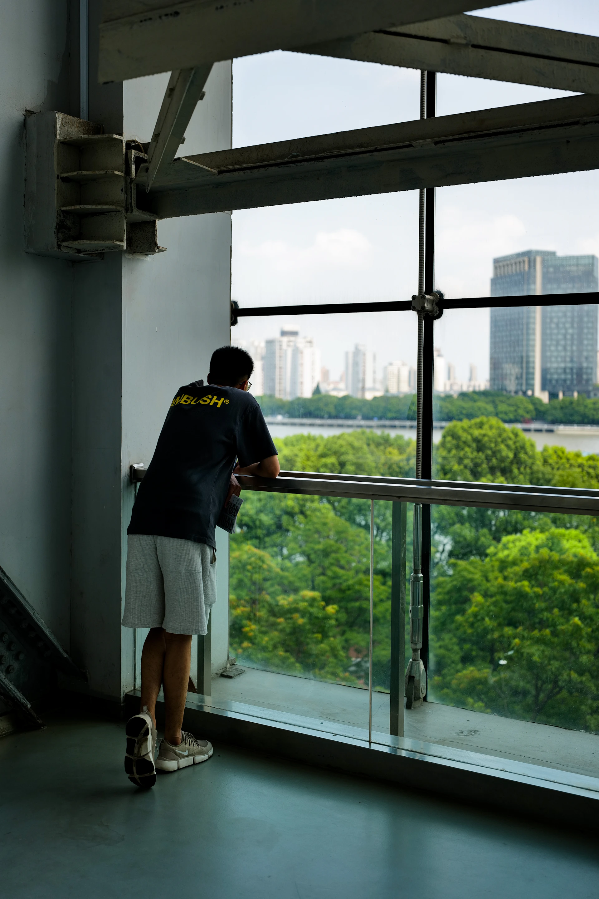 a man looking out a window at a city