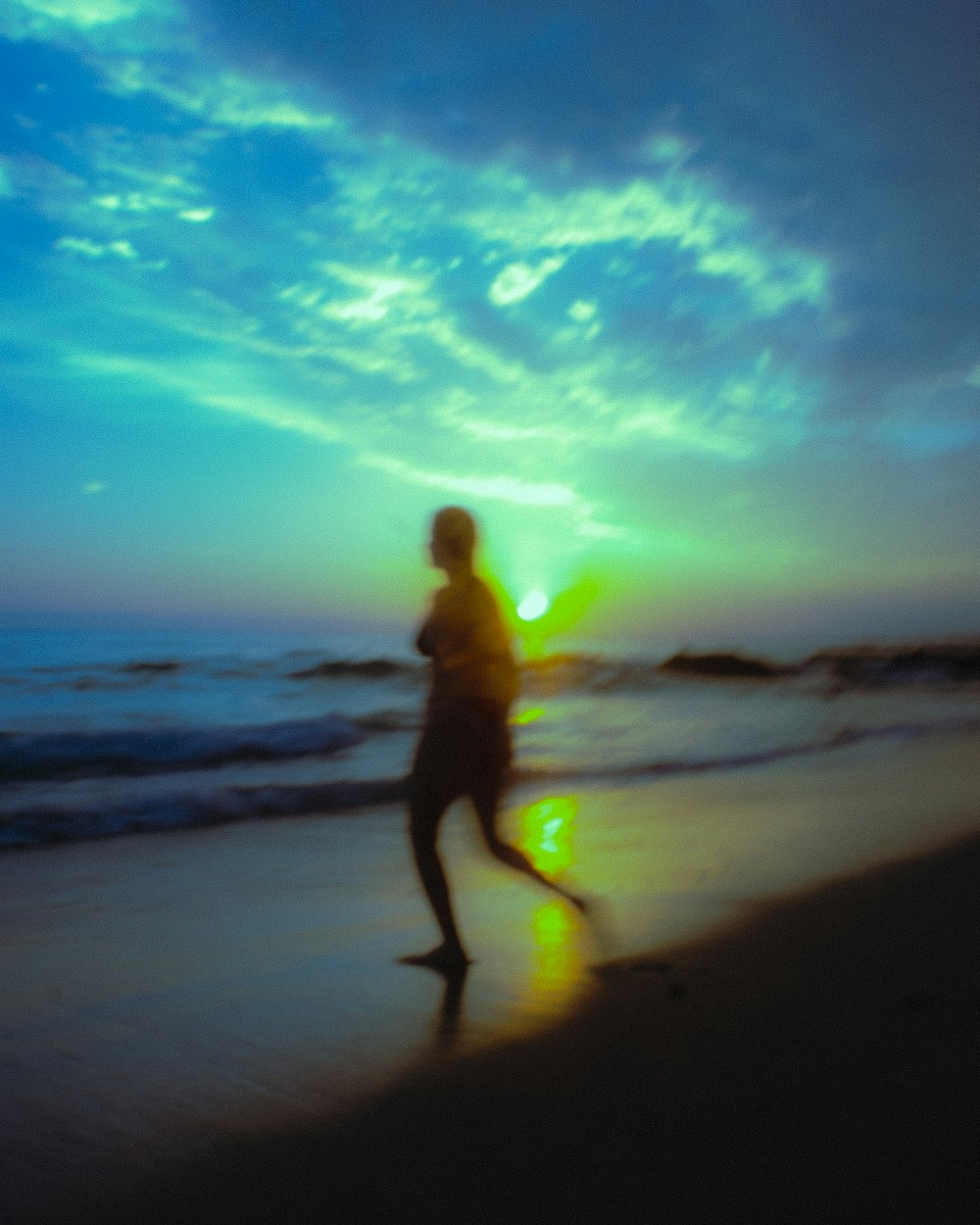 a man running on the beach at sunset