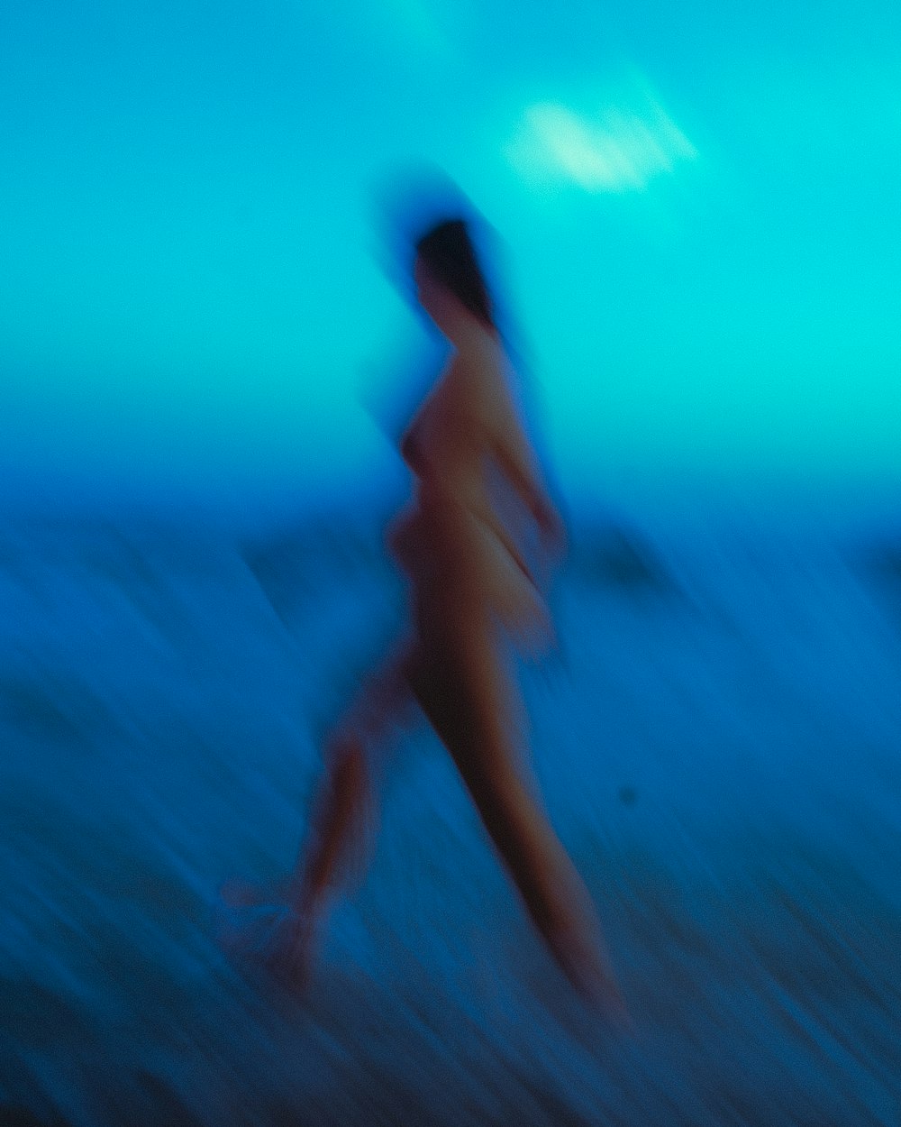 a blurry photo of a person running on the beach