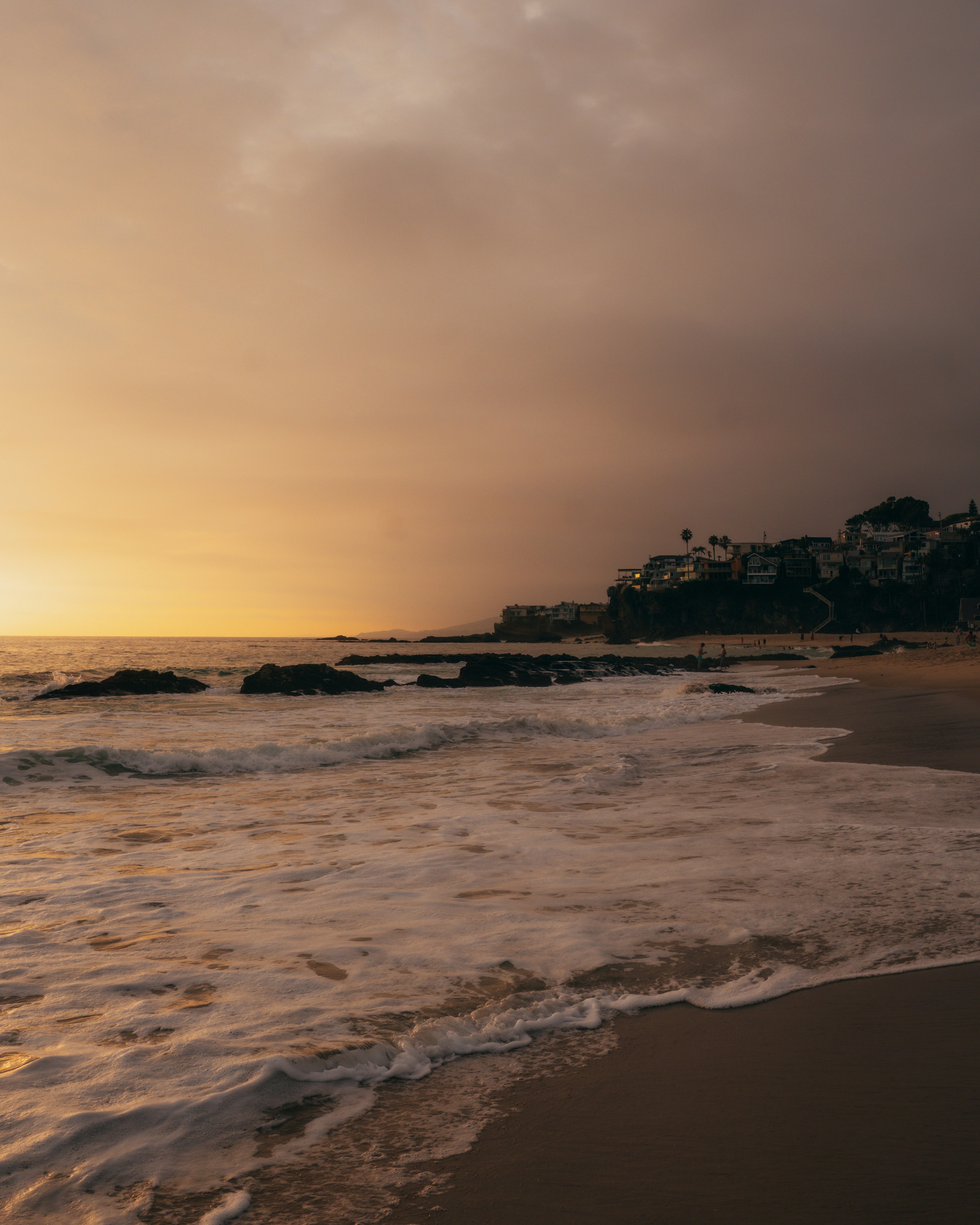 Die Sonne geht über dem Meer und den Häusern am Ufer unter