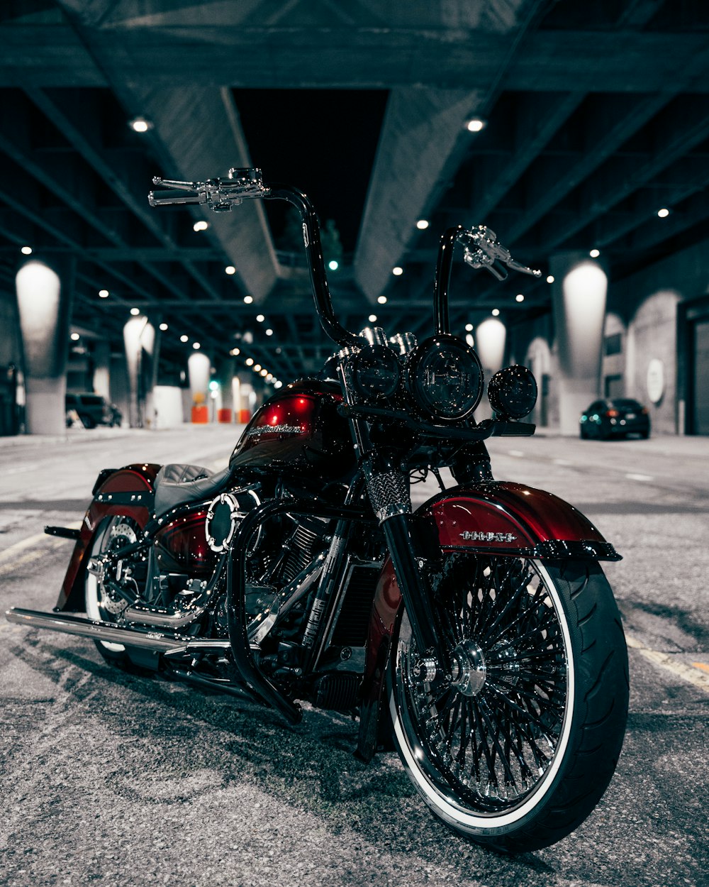 a red and black motorcycle parked in a parking garage