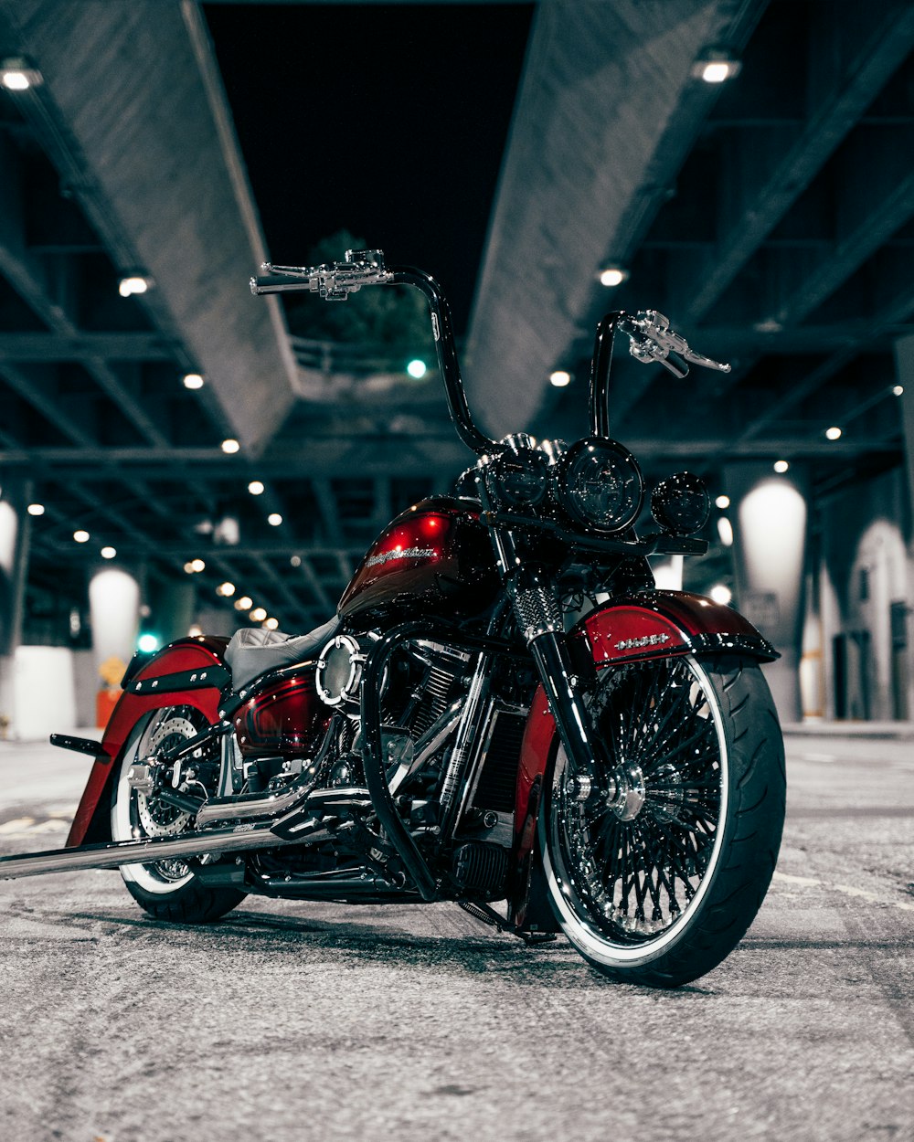 a red and black motorcycle parked in a parking garage
