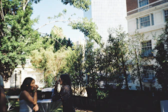 Two people engaging in a lively conversation outdoors with city background in soft focus