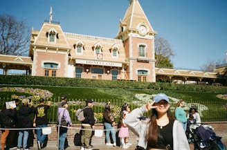 A cheerful travel agent standing in front of Cinderella Castle at Walt Disney World.