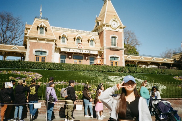 A cheerful travel agent standing in front of Cinderella Castle at Walt Disney World.
