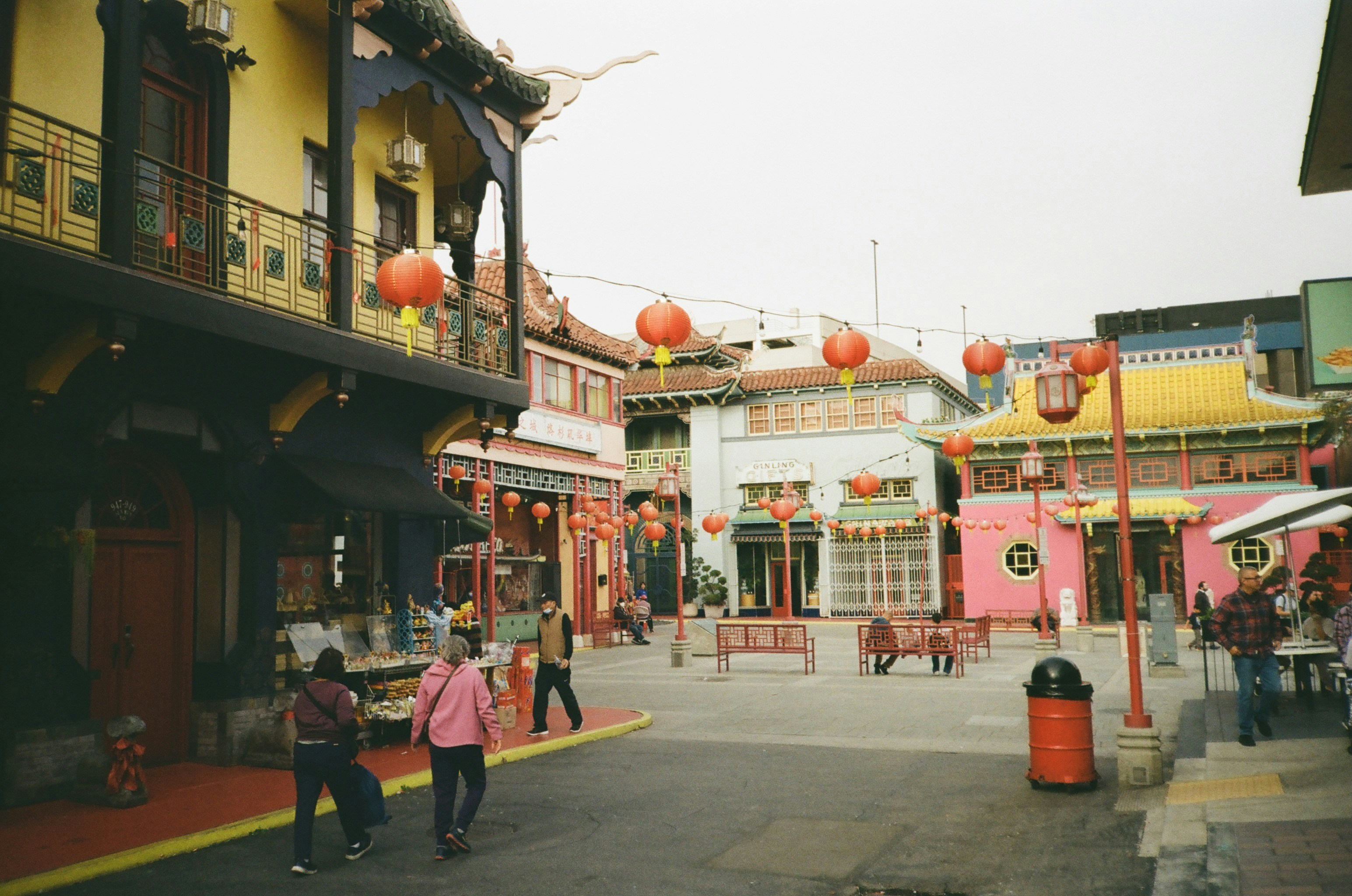 a group of people walking down a street next to tall buildings