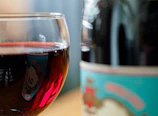 A close-up of a wine bottle with a glass beside it.