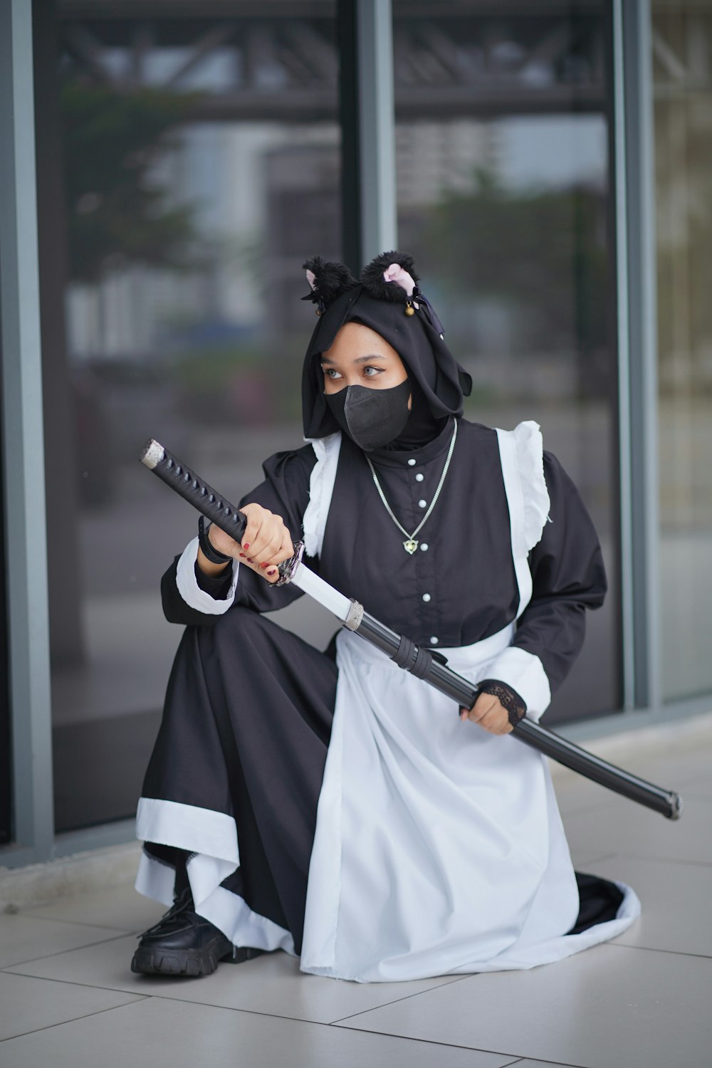 a woman in a black and white outfit holding a sword