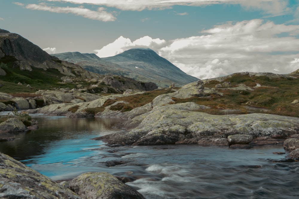 a stream running through a rocky mountain valley