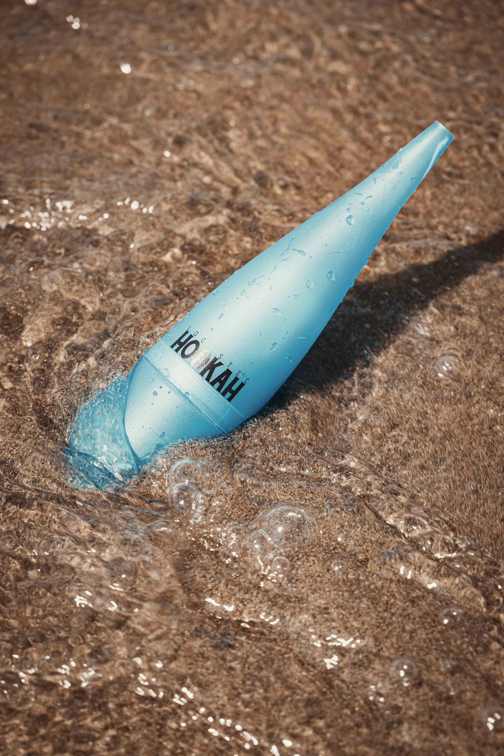 a blue tube of toothpaste floating in a pool of water