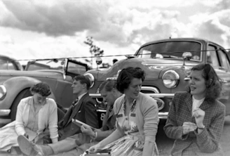 Members gathered around a historic vehicle sharing stories and laughter.
