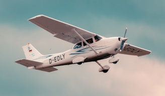 a small airplane flying through a cloudy sky
