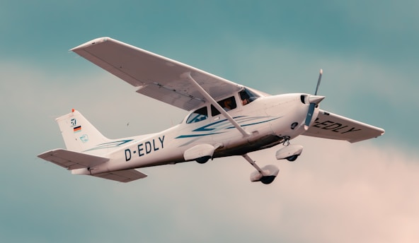 a small airplane flying through a cloudy sky