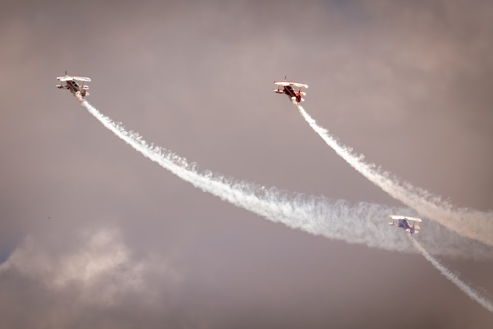 a group of airplanes flying through a cloudy sky