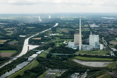 Environmental engineer reviewing documents near a green industrial facility.