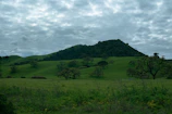A serene landscape featuring rolling hills under a cloudy sky.