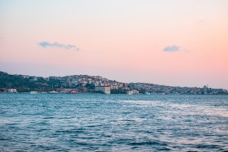 A serene sunset over an Asian coastal city skyline, blending modern luxury with tranquil natural beauty.