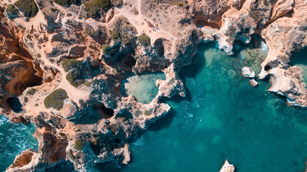 an aerial view of a body of water surrounded by rocks