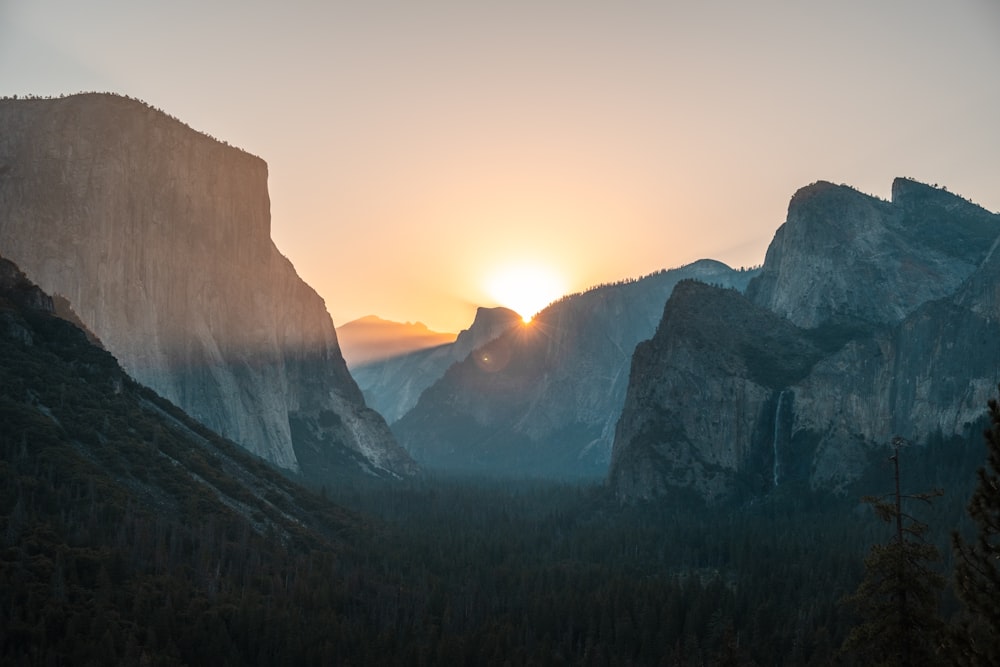 the sun is setting over a mountain range