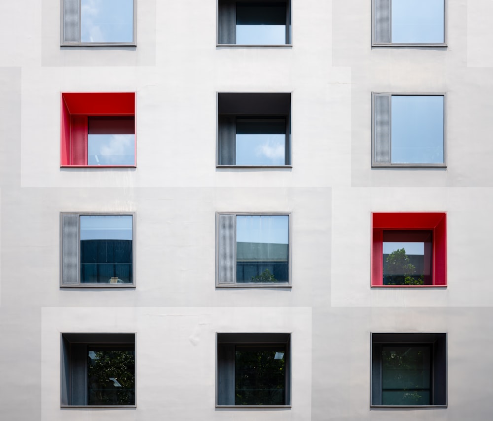 a white building with many windows and a red window