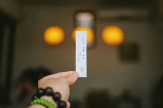 Close-up of a person holding an admit card with exam details visible.