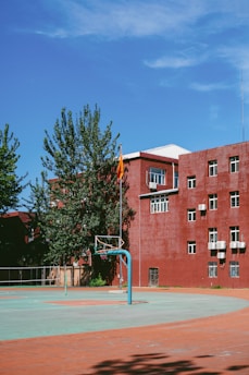 a basketball court in front of a red building