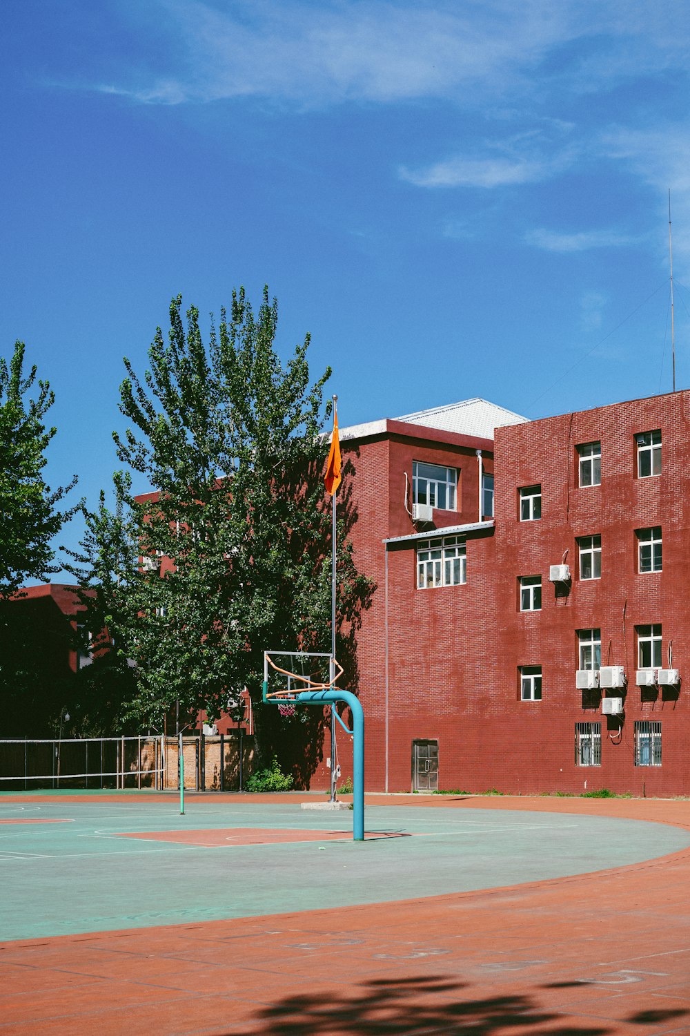 a basketball court in front of a red building