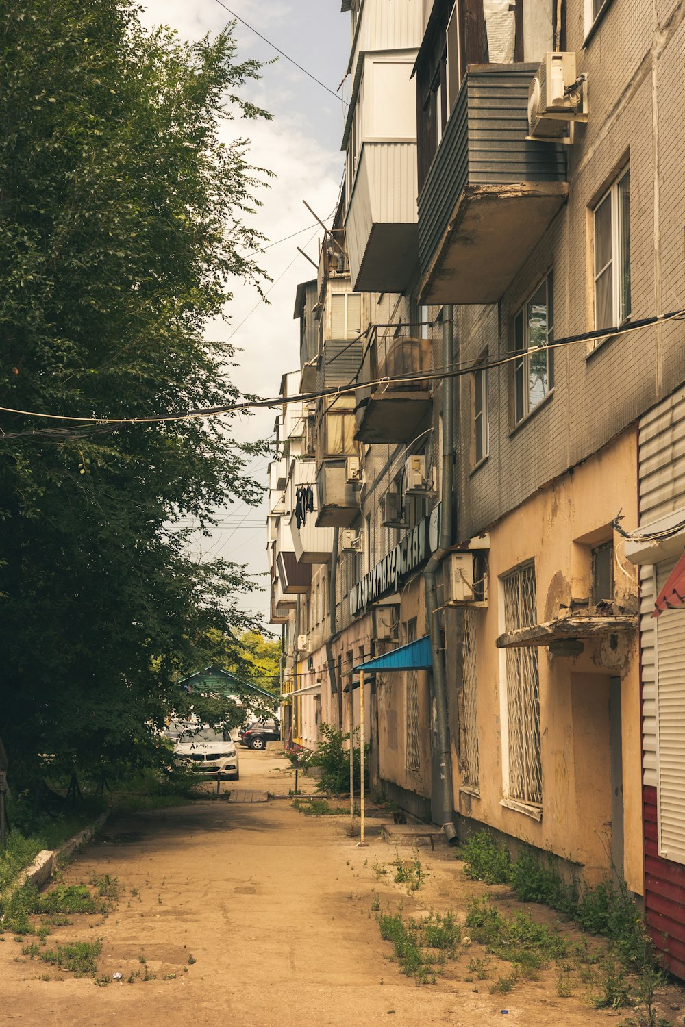 a dirt road between two buildings with balconies