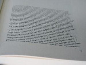 A page from a book with printed text in black ink on white paper. The text discusses historical or biblical events involving names, numbers, and references to sacrifices and religious practices. The page has a slightly curved orientation, and some parts of the text are out of focus due to the depth of field.
