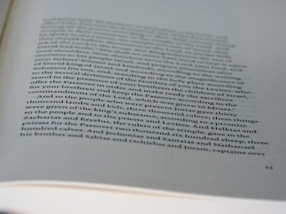 A page from a book with printed text in black ink on white paper. The text discusses historical or biblical events involving names, numbers, and references to sacrifices and religious practices. The page has a slightly curved orientation, and some parts of the text are out of focus due to the depth of field.