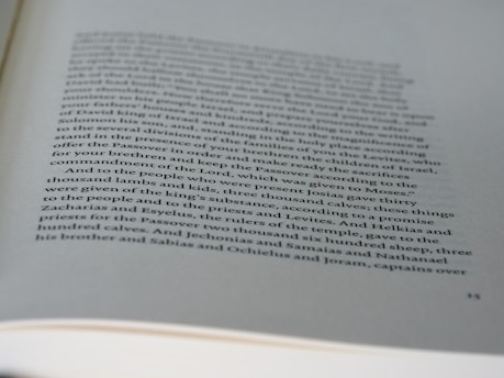 A page from a book with printed text in black ink on white paper. The text discusses historical or biblical events involving names, numbers, and references to sacrifices and religious practices. The page has a slightly curved orientation, and some parts of the text are out of focus due to the depth of field.