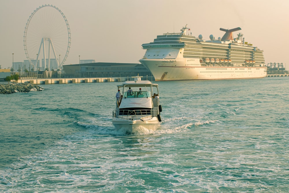 Un pequeño bote en el agua con un gran crucero al fondo