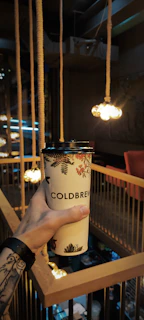 Lifestyle shot of a customer wearing a statement t-shirt while sipping coffee at a cozy café.