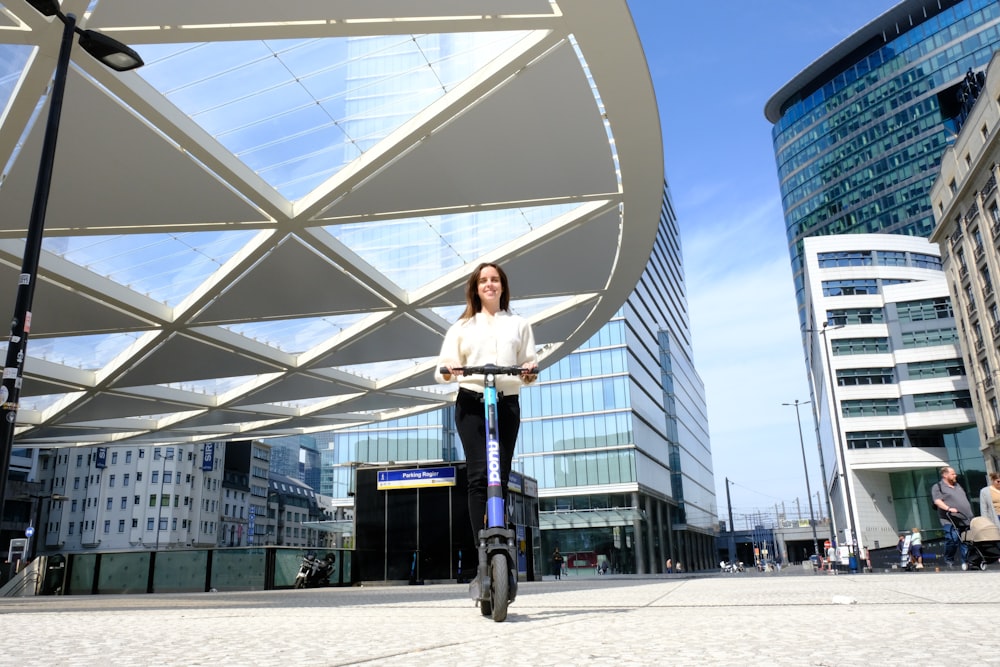 a woman riding a scooter on a city street