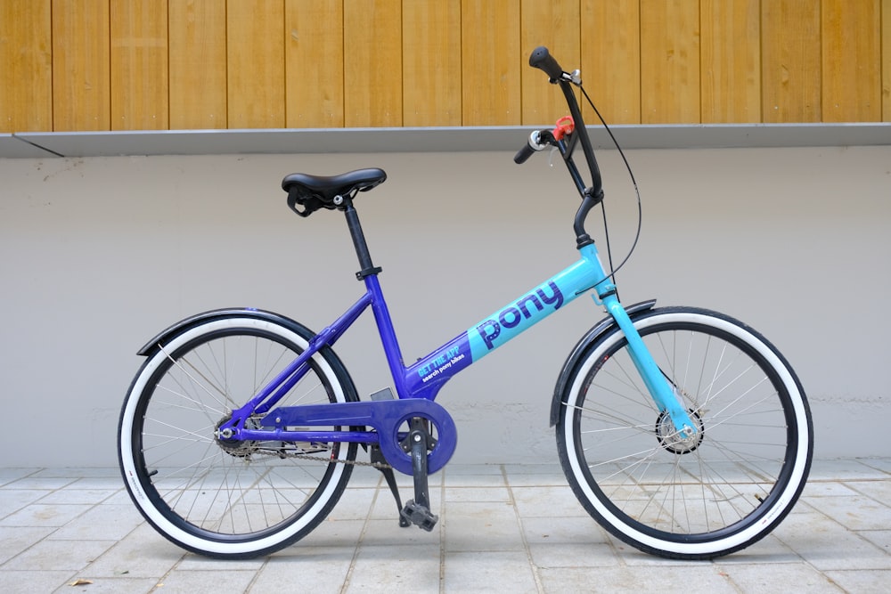 Una bicicletta blu parcheggiata di fronte a un edificio