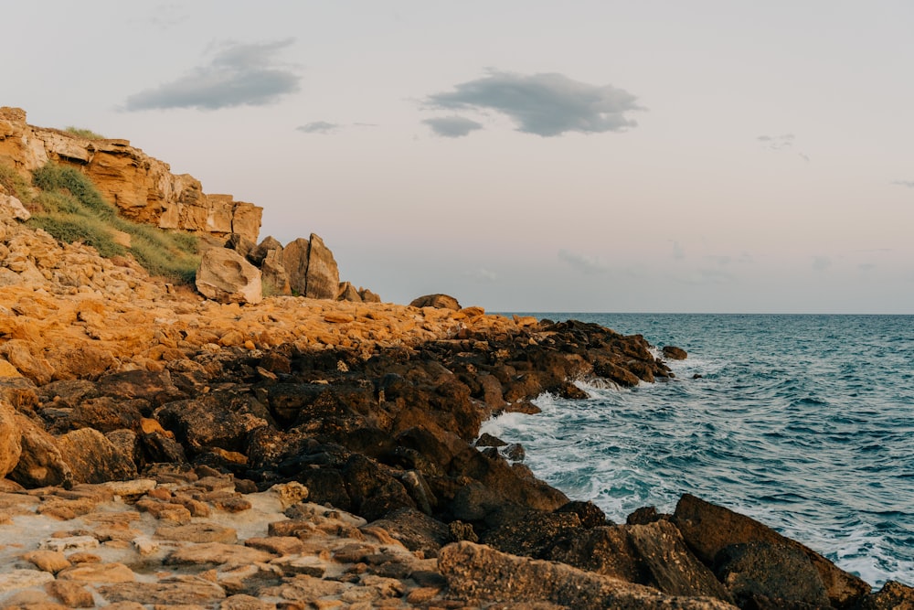 a rocky shore line with a body of water