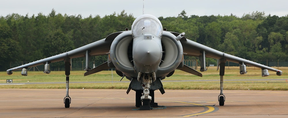 a fighter jet sitting on top of an airport tarmac