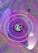 A stylized, abstract image featuring a central logo surrounded by a series of concentric circles. The backdrop consists of a tiled surface with a vibrant combination of purple and pink hues. Various spheres and grid lines add a sense of depth and motion to the composition.