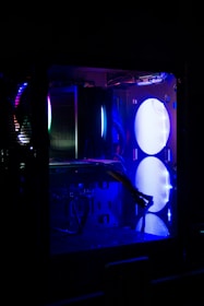 A side profile of a DIY computer case featuring transparent panels and colorful LED strips, set against a dark, techy backdrop.