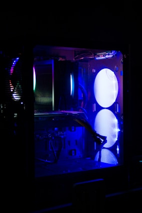 A sleek black computer case with electric blue LED lights illuminating its interior.