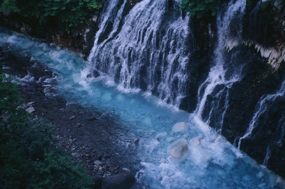 a waterfall with blue water running down it