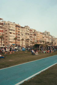 A vibrant community of residents chatting happily outside a well-maintained block.
