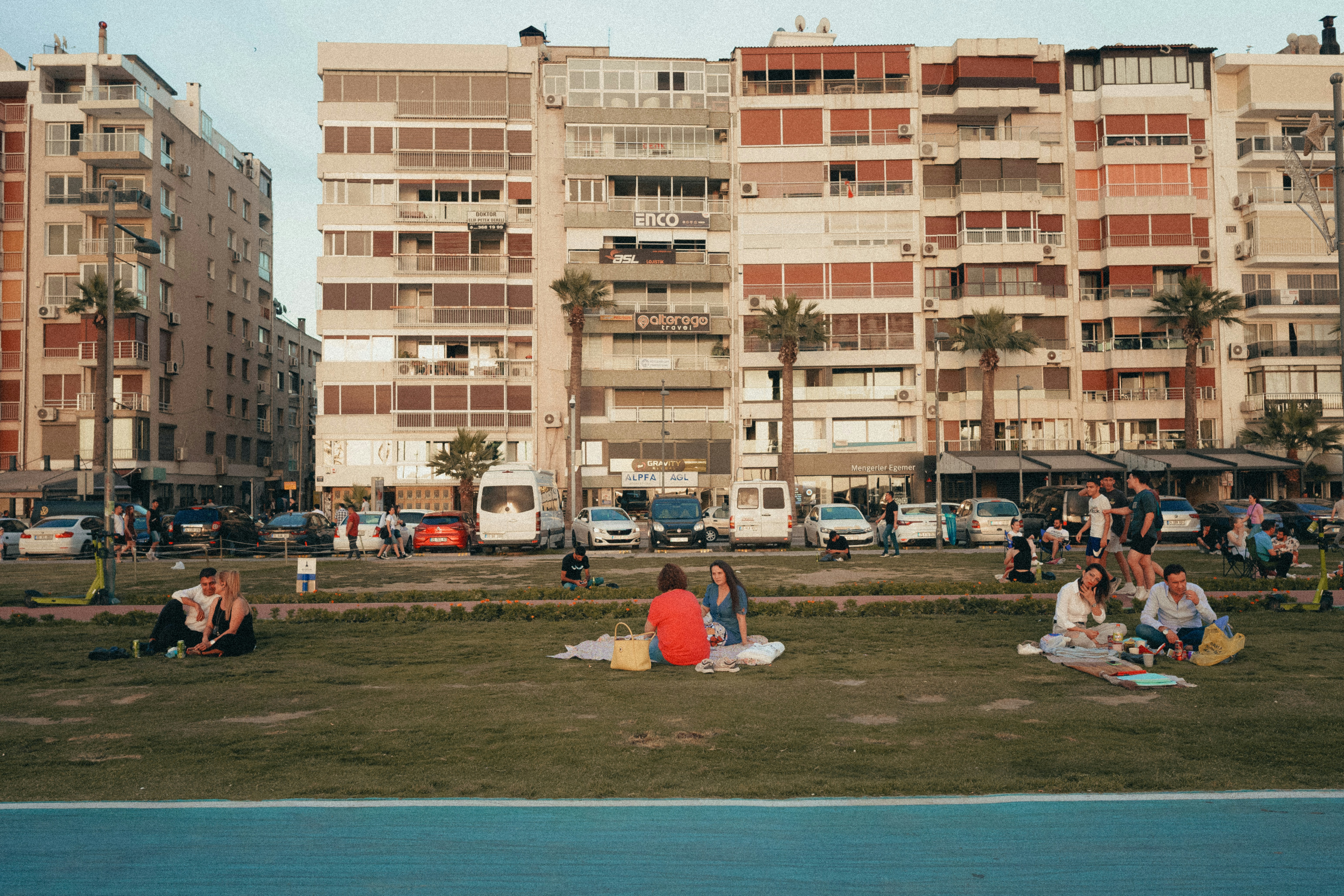 a group of people sitting on the grass in front of a building, 