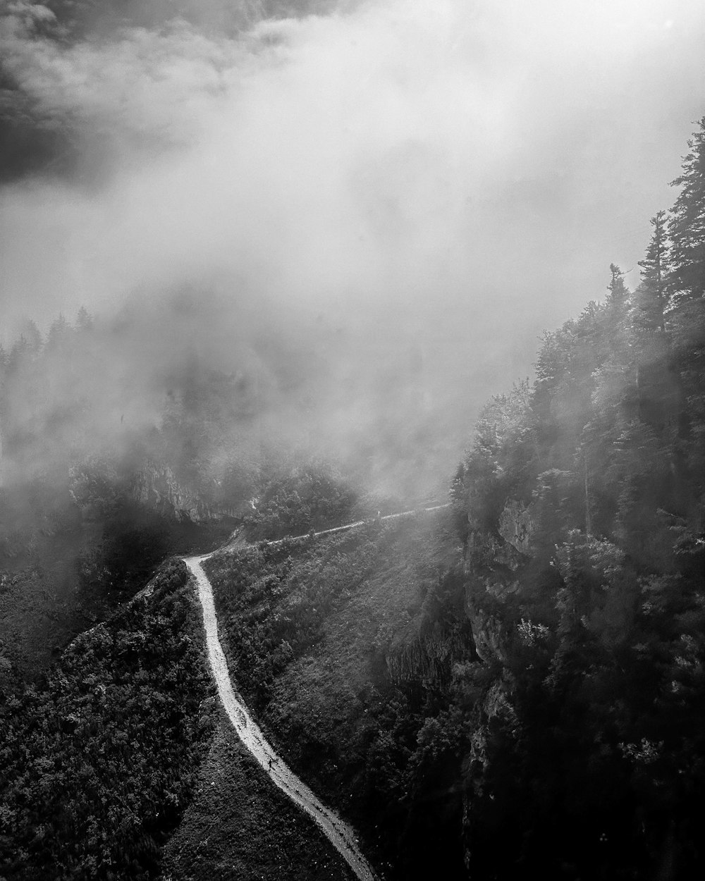a black and white photo of a winding road