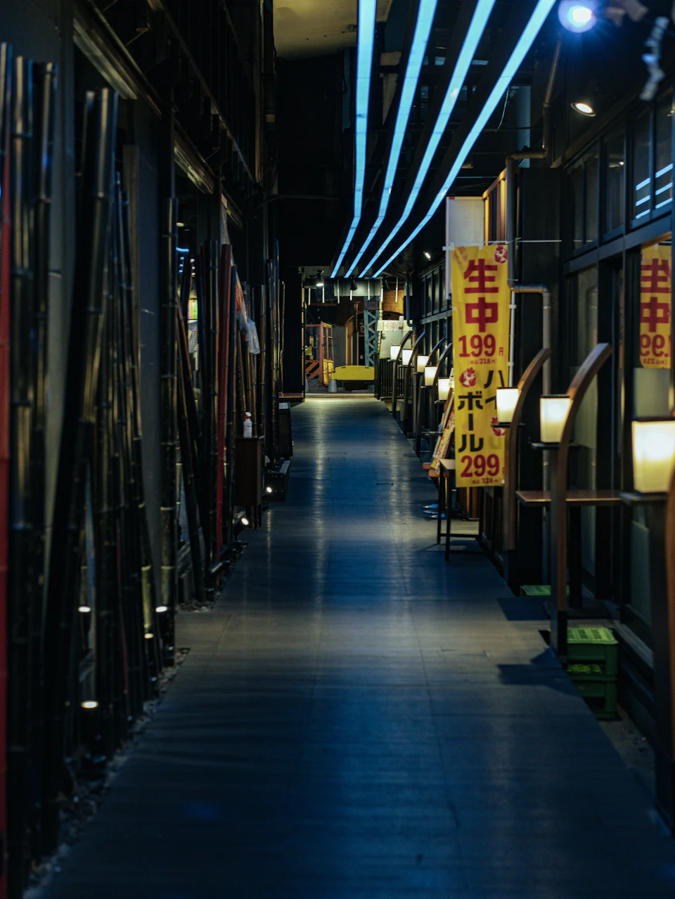 Long, narrow hallway with polished wooden floor and red lanterns hanging from ceiling