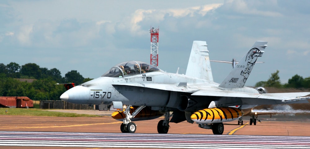 a fighter jet sitting on top of an airport runway